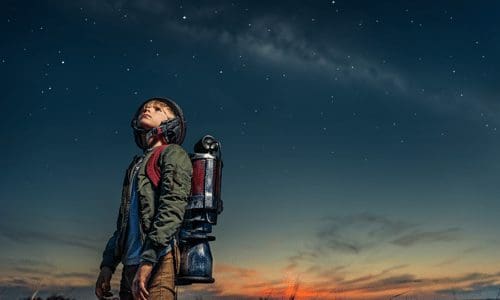 A boy with a jet pack staring at the night sky