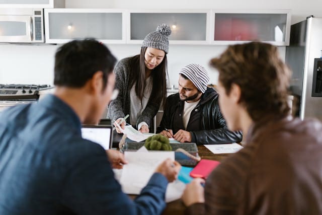Business founders and startup employees sitting around a desk checking business launch documents.