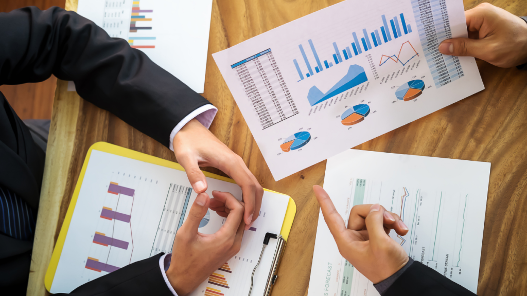 Business partners discussing financial growth and performance charts during a small business data review meeting.